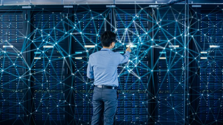 An IT engineer standing beside open server rack cabinets