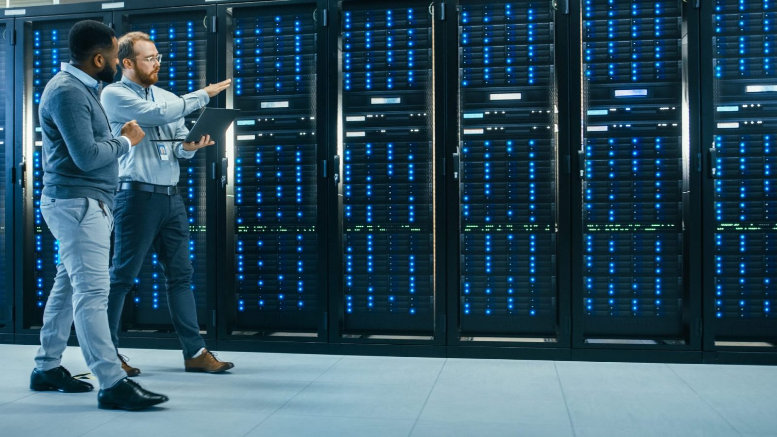 Two IT employees walking in a data server room